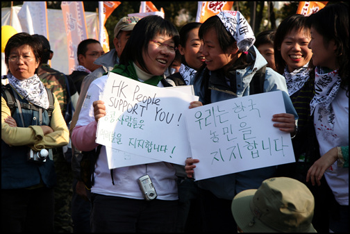 빵과 음료를 들고 찾아 온 홍콩 대학생들이 한국 농민을 격려하는 글을 써서 펼친다. 